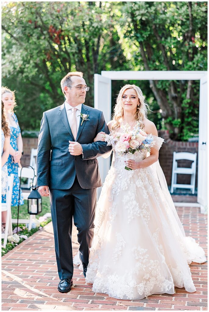 Bride and father of the bride walk down the aisle in wedding ceremony entrance at fairytale-themed Historic Mankin Mansion wedding in June | Richmond wedding photographer