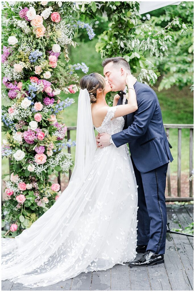 Bride and groom share their first kiss at their tent covered ceremony at The Manor at Airmont wedding | Northern VA Wedding Photographer