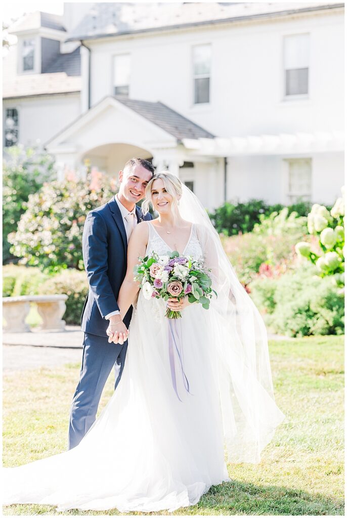 Bride and Groom pose in front of wedding venue with pastel lavender bridal bouquet and bright blue groom's suit

River Farm Wedding | Alexandria Wedding Photographer