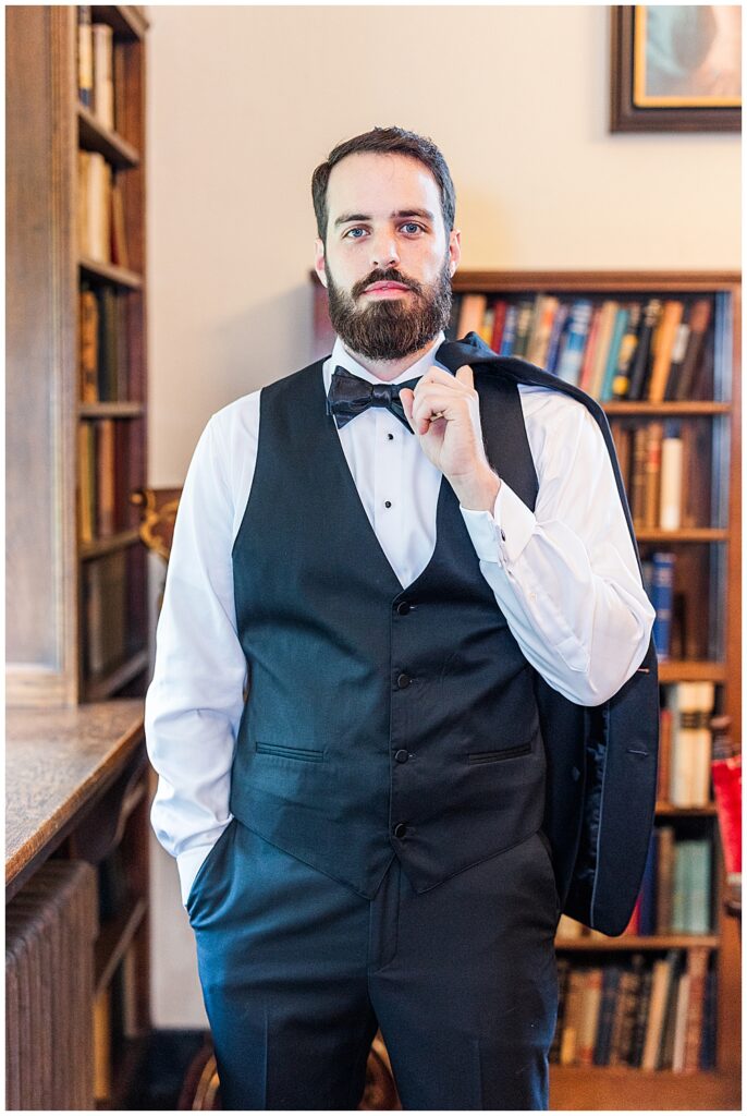 A groom poses for a formal portrait while getting ready for his Virginia House wedding in Richmond in the fall. Photo by a Richmond wedding photographer, Emily Nicole Photography.