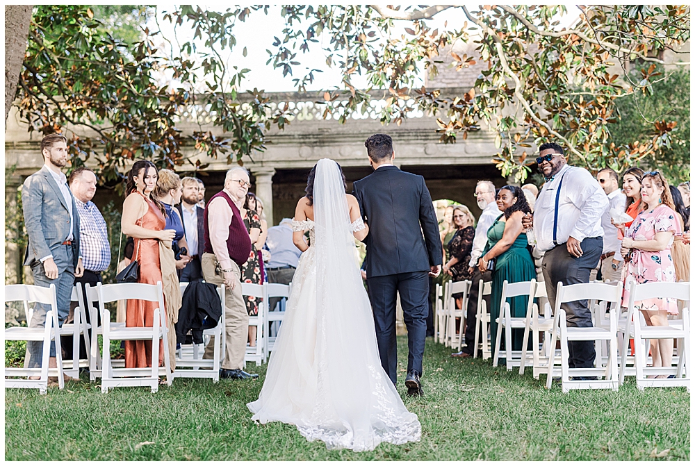 The bride is escorted down the aisle by her brother at her Virginia House wedding ceremony in Richmond in the fall. Photo by a Richmond wedding photographer, Emily Nicole Photography.
