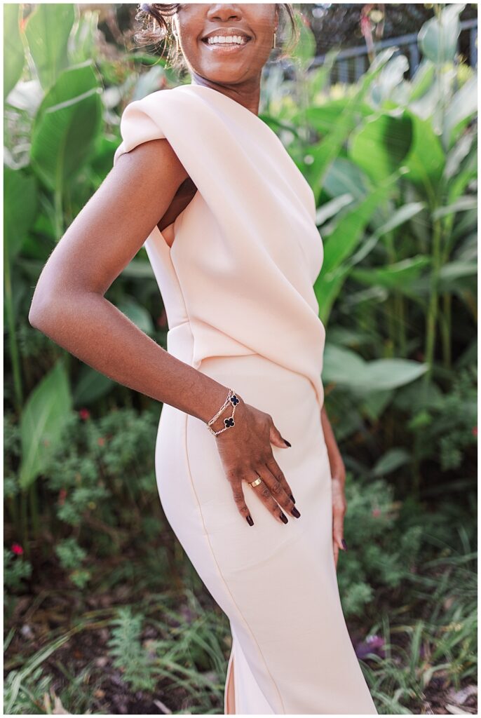 Inspiration for a simple yet elegant wedding guest look. A wedding guest poses in a sleek, blush dress, accessorized with a Cartier ring and Van Cleef & Arpels bracelet. Photo by a Richmond wedding photographer, Emily Nicole Photography.