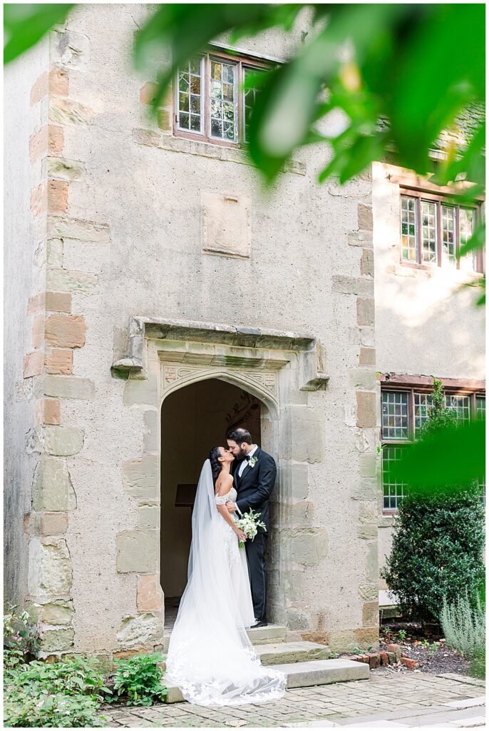 A bride and groom pose in one of the raised Tudor-style gardens of the Virginia House in Richmond, serving as their enchanting, fairytale estate wedding venue. Photos by a Richmond wedding Photographer, Emily Nicole Photography.