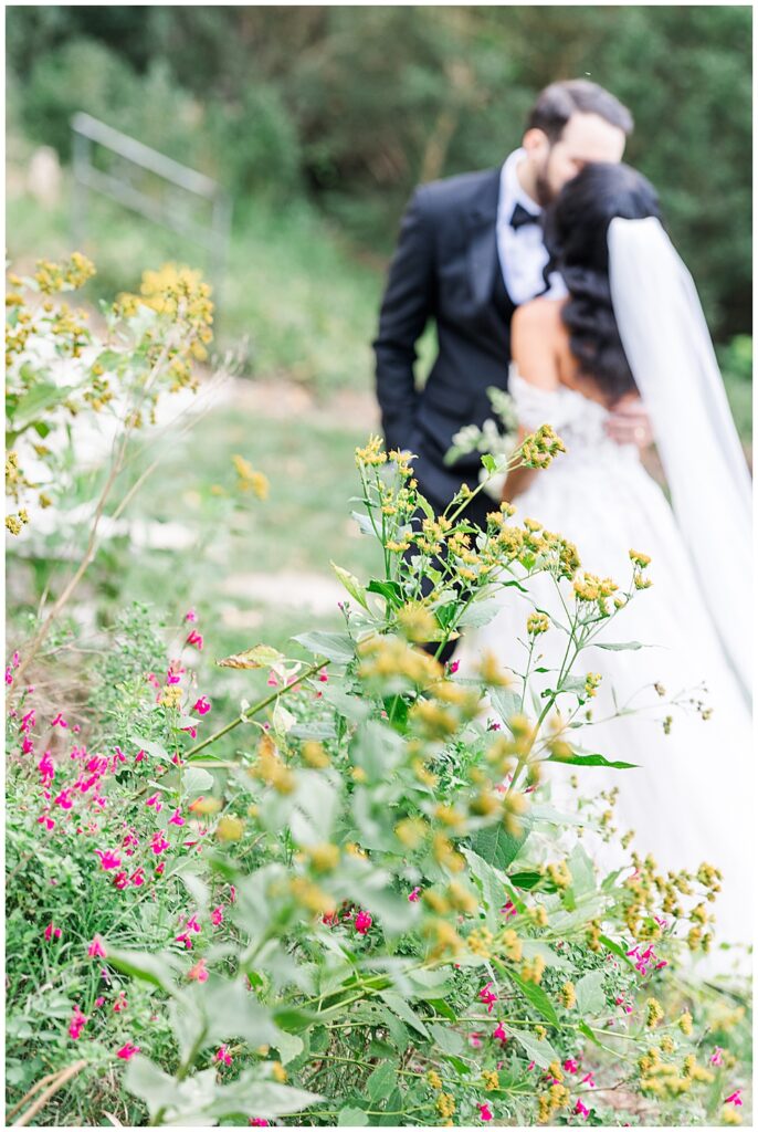A bride and groom pose in one of the sunken Tudor-style gardens of the Virginia House in Richmond, serving as their enchanting, fairytale estate wedding venue. Photos by a Richmond wedding Photographer, Emily Nicole Photography.