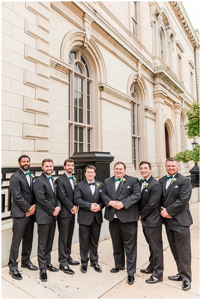 George Peabody Library wedding groomsmen photos outside one of the best wedding venues in Baltimore, MD. Taken by a DMV Wedding Photographer.
