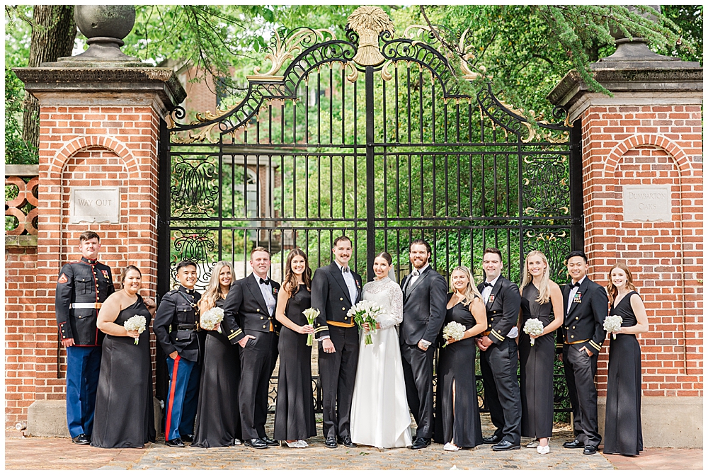 Military black tie wedding bridal party photo in front of the Dumbarton Oaks Museum gate in Georgetown, taken after a traditional Catholic wedding ceremony at Basilica School of Saint Mary in Washington, D.C. | Photo taken by D.C. wedding photographer