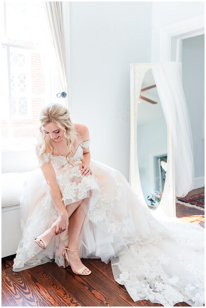 Bride putting on wedding shoes at her fairytale-themed Historic Mankin Mansion wedding in June | Richmond wedding photographer
