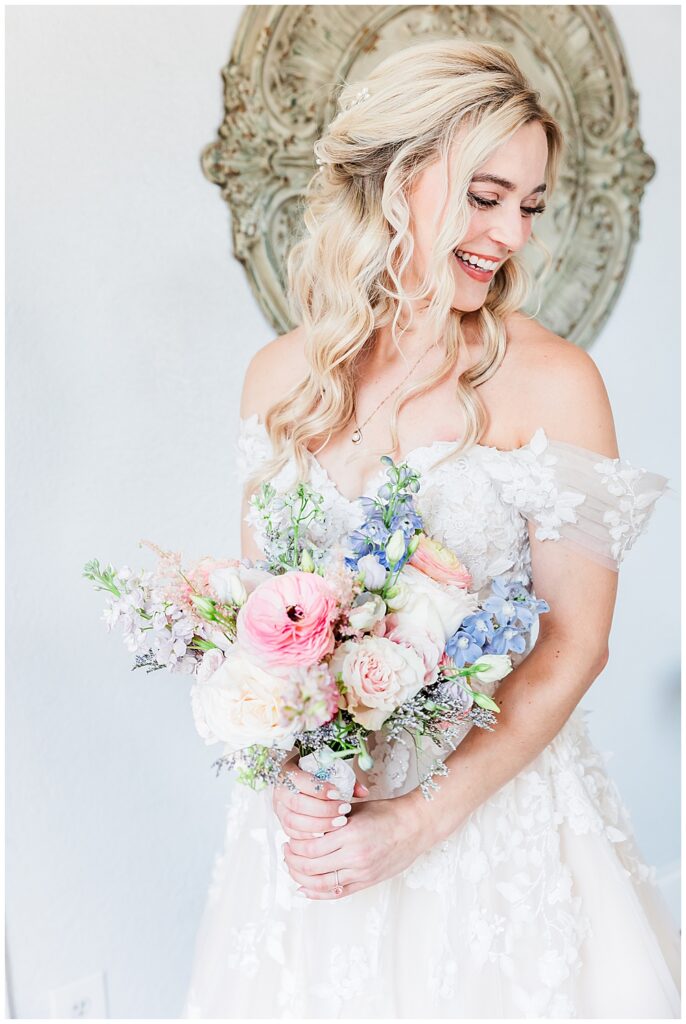 Smiling bride with blonde hair holding a bridal bouquet of assorted pastel-tone wedding flowers | Fairytale-themed Historic Mankin Mansion wedding in June | Richmond wedding photographer