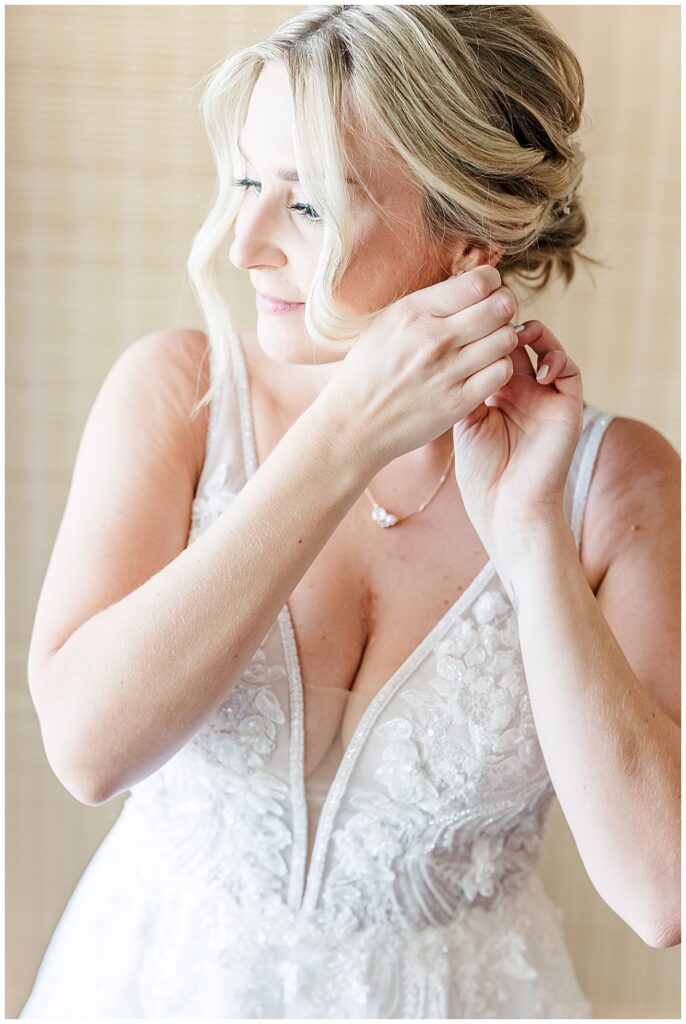 A bride puts on her Olive & Piper earrings, her blonde hair in a romantic, wispy updo

River Farm Wedding | Alexandria Wedding Photographer