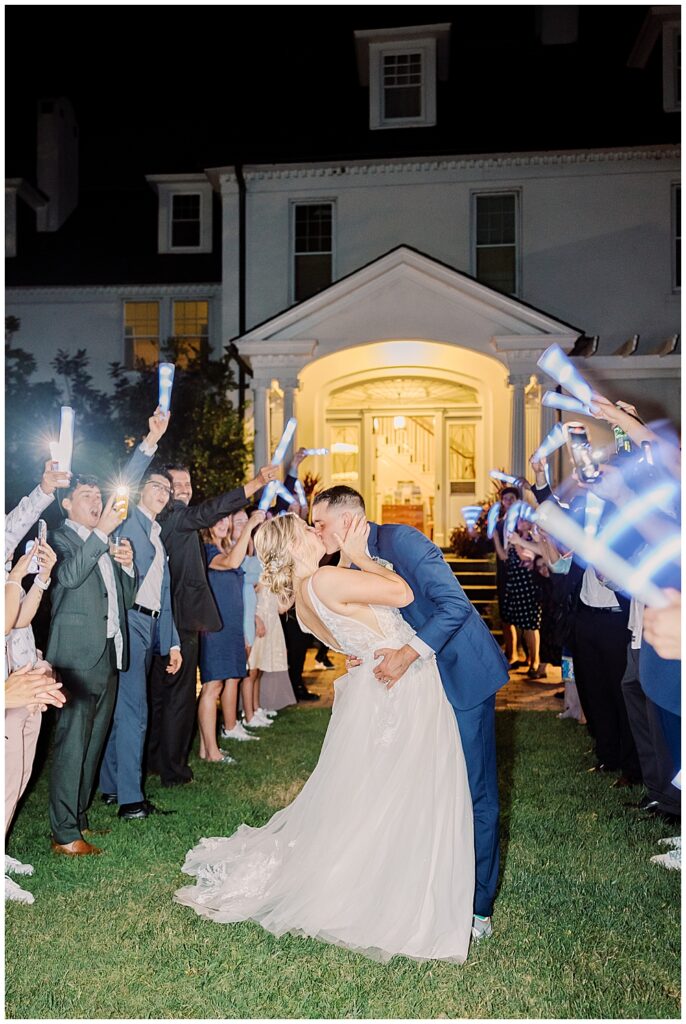 Bride and Groom kiss during their send-off as wedding guests wave blue LED wands

River Farm Wedding | Alexandria Wedding Photographer