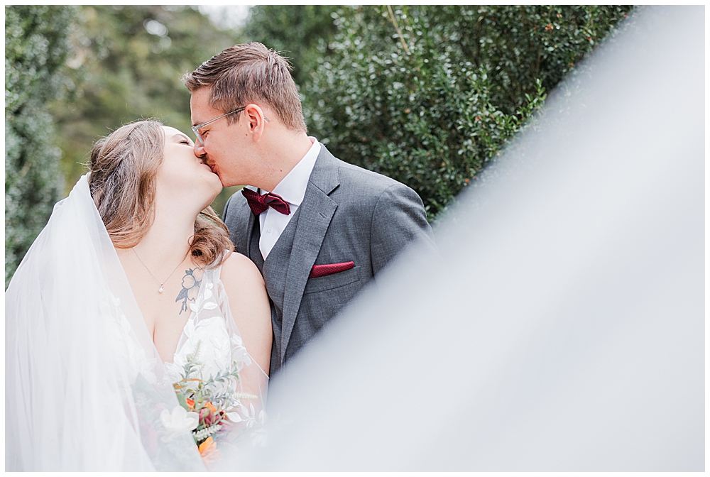 A close-up shot of a bride and groom kissing for a photo with the bride's long veil swooping off to the side of the frame.

Rust Manor House Wedding | Leesburg Wedding Photography | VA Wedding Venues