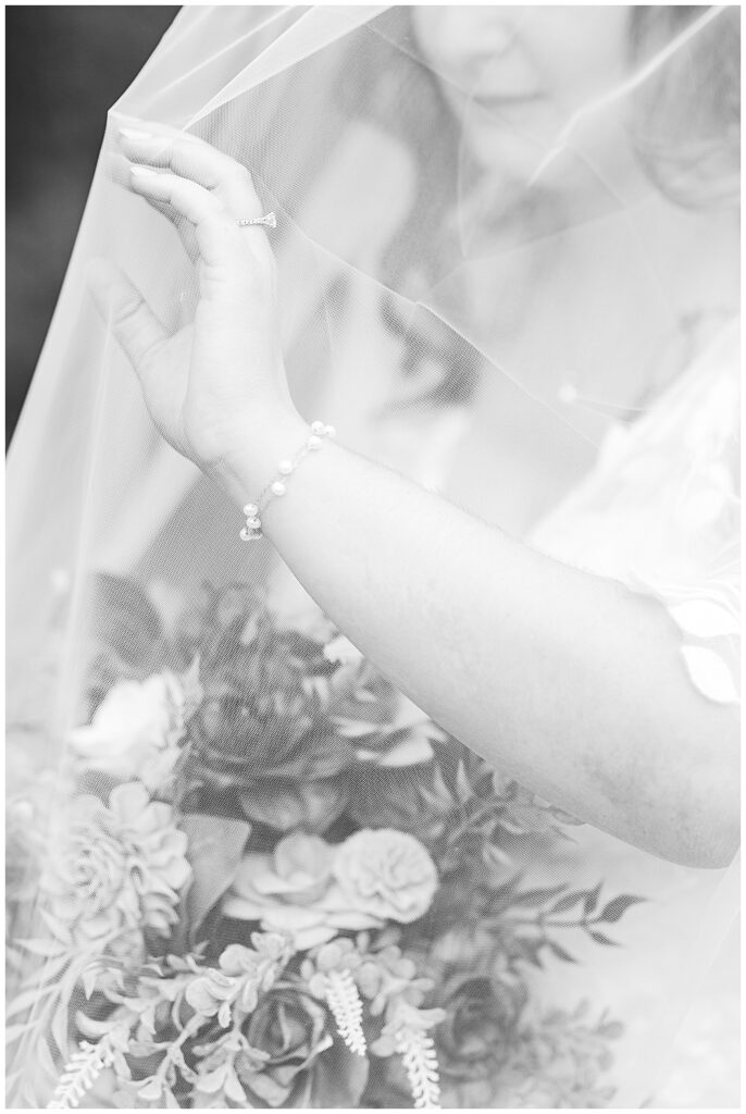 A black and white close-up shot of a bride under her blusher veil, her hand pushing the veil from her face wearing a delicate pearl bracelet.

Rust Manor House Wedding | Leesburg Wedding Photography | VA Wedding Venues