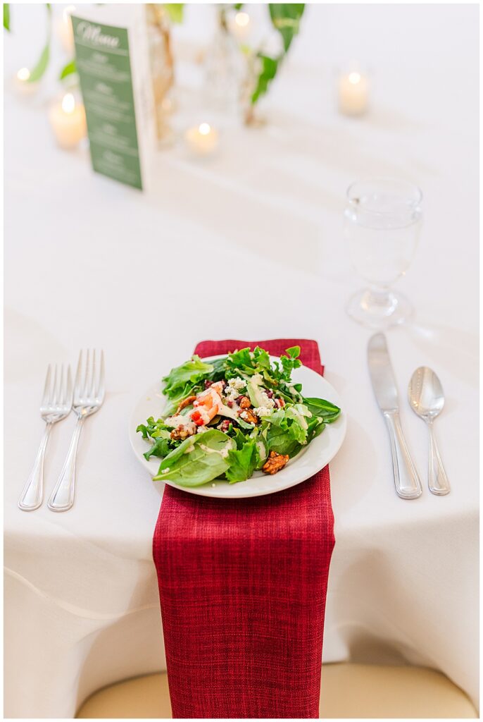 A wedding reception place setting with white table cloth, maroon napkin under a plated salad, surrounded by silverware and tea light candles.

Rust Manor House Wedding | Leesburg Wedding Photography | VA Wedding Venues